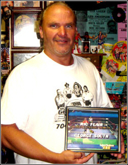 George South holds a framed print from his 1988 televised match with Ric Flair.